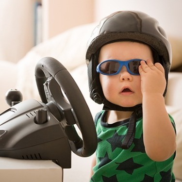 a child with sunglasses and a racing helmet