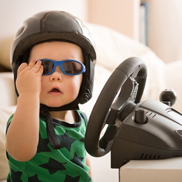 a child with sunglasses and a racing helmet
