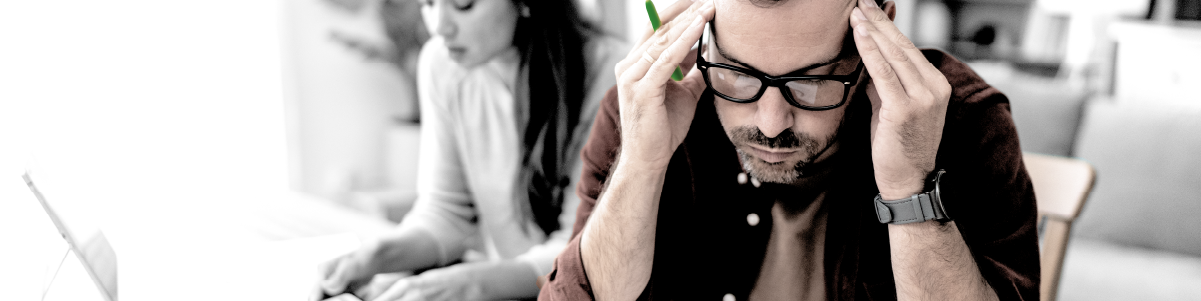 IMAGE: Man sitting next to a woman inside a house and studying his credit score on paper.