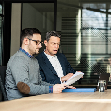 IMAGE: Two men looking at paperwork in an office