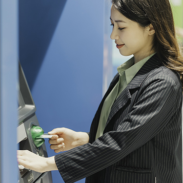 IMAGE: Woman withdrawing cash at an ATM