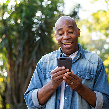 IMAGE: Man looking happy while holding cell phone