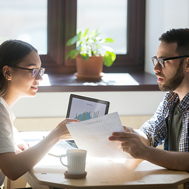 IMAGE: Couple discussing paperwork at a table