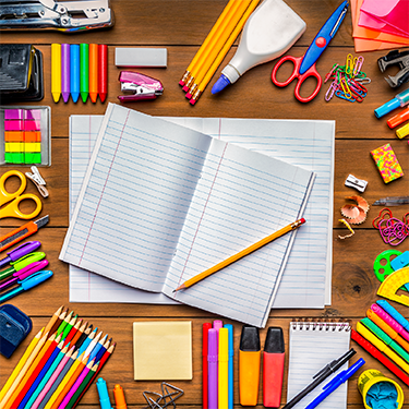 IMAGE: wooden tabletop with school supplies spread out