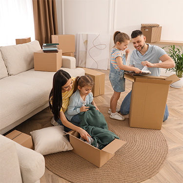 IMAGE: Family opening moving boxes inside living room