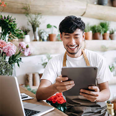 IMAGE: Man holding tablet in flower shop