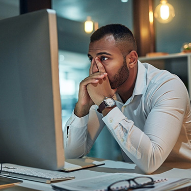 IMAGE: Man looking concerned at computer monitor.