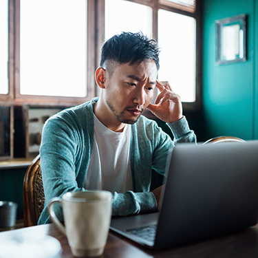 IMAGE: Man looking concerned at laptop screen