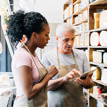 IMAGE: Shop owners looking at a tablet and supplies