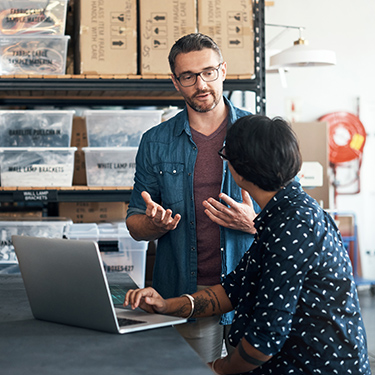 IMAGE: Business partners discussing plans in a warehouse