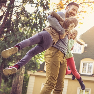 father playing with his children outdoors