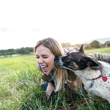 IMAGE: Woman with dog kissing her cheek