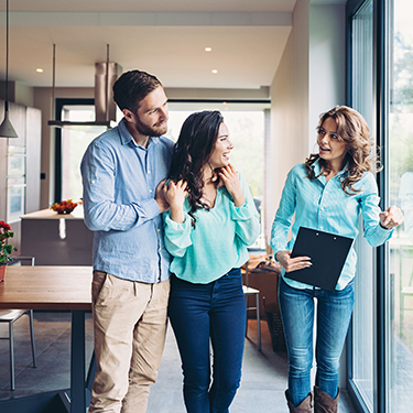 IMAGE: Couple looking at house with realtor