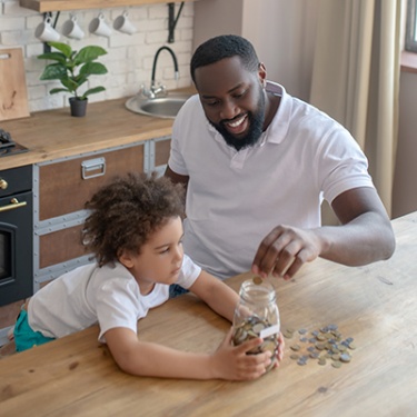 a man counting coins with his child