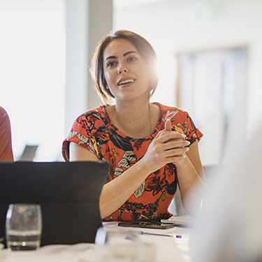 IMAGE: Woman in business meeting actively listening.