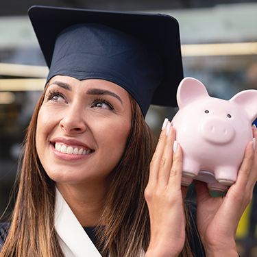 IMAGE: College grad smiling holding piggy bank