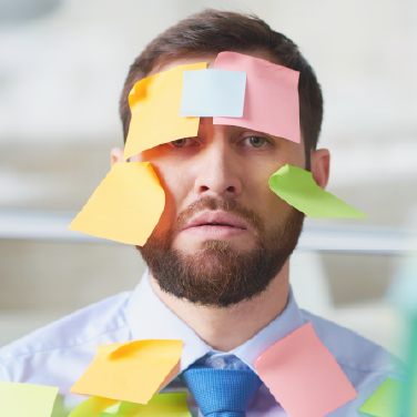 IMAGE: Man at job covered in post-it notes