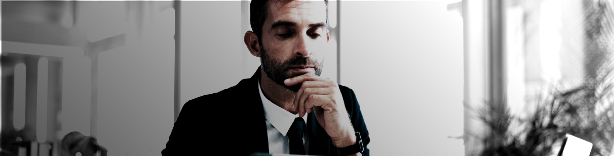 IMAGE: Man in a suit looking concerned inside an office.