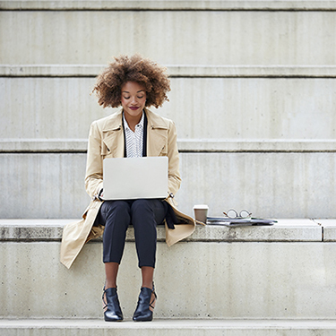 IMAGE: Modern businesswoman on step with laptop